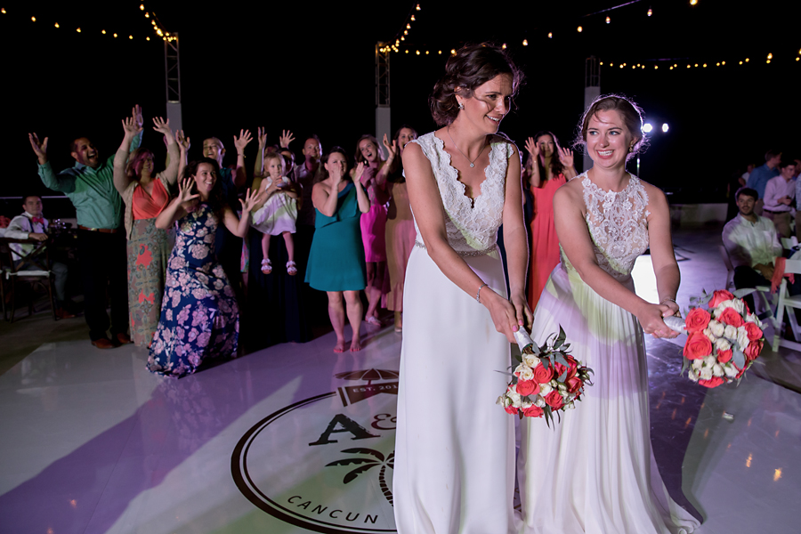 Two brides tossing bouquet